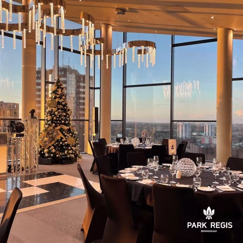 Tables set for dinner beneath chandeliers at the Park Regis Sky Gallery, Birmingham, overlooking the city skyline